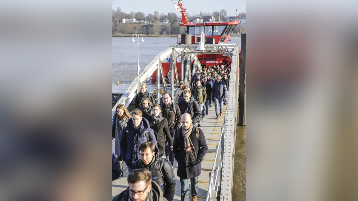 Am Fähranleger verlassen Mitarbeiter die Hadag-Fähre 