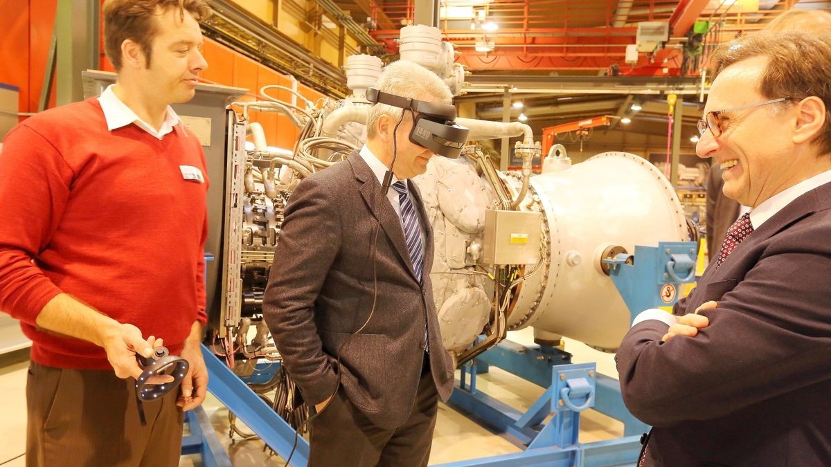 NRW Wirtschaftsminister Andreas Pinkwart (FDP, Mitte) beim Oberhausener Werksbesuch mit einer Datenbrille. 