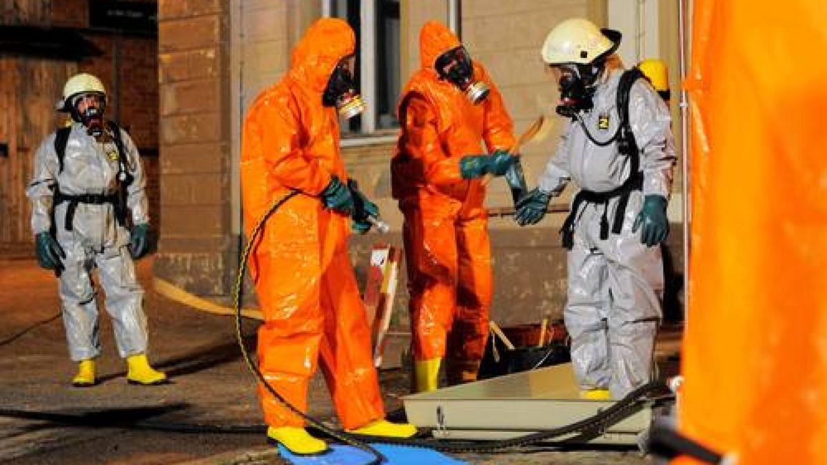 Feuerwehrmänner in Spezialanzügen pumpen die chemische Flüssigkeit ab. Foto: Sascha Fromm
