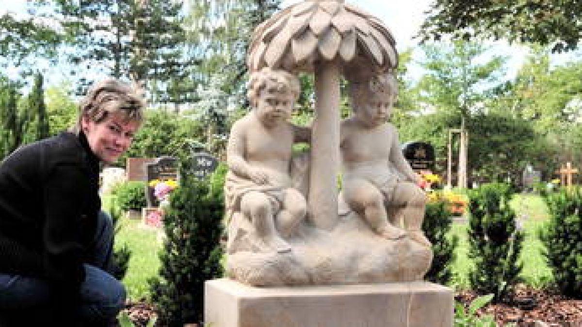 Auf dem Friedhof in Arnstadt hat der restaurierte
Stein mit zwei Putten vor dem Kinder-Gräberfeld - dessen Umfeld hier von Dagmar Adam, Mitarbeiterin Friedhofsverwaltung Arnstadt gepflegt wird - seinen Platz gefunden. Foto: Christoph Vogel