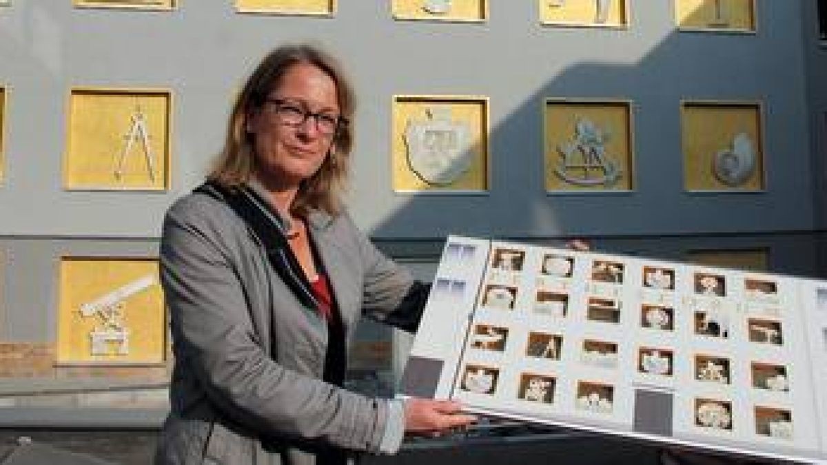 Sabine Jeschke, Bauleiterin Hochbau beim Perthes-Forum Gotha, steht mit dem Modell für die künstlerische Fassadengestaltung vor dem fertigen Werk. Foto: Claudia Klinger
