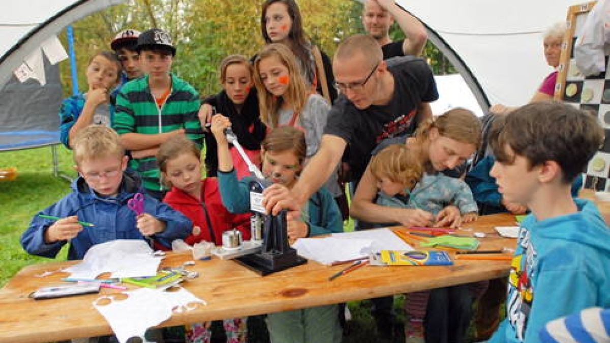 19.09. Weimar. Zum Weltkindertag luden das Kinderhaus und das Team Jugendarbeit zum Kinderfest auf den Spielplatz am Spitalweg. Trotz zeitweise Regen war die Stimmung toll. Im Bild: Paula (8) an der Buttonmaschine; Marcus Hohmann vom Café Conti hilft ihr. Foto: Hannsjörg Schumann