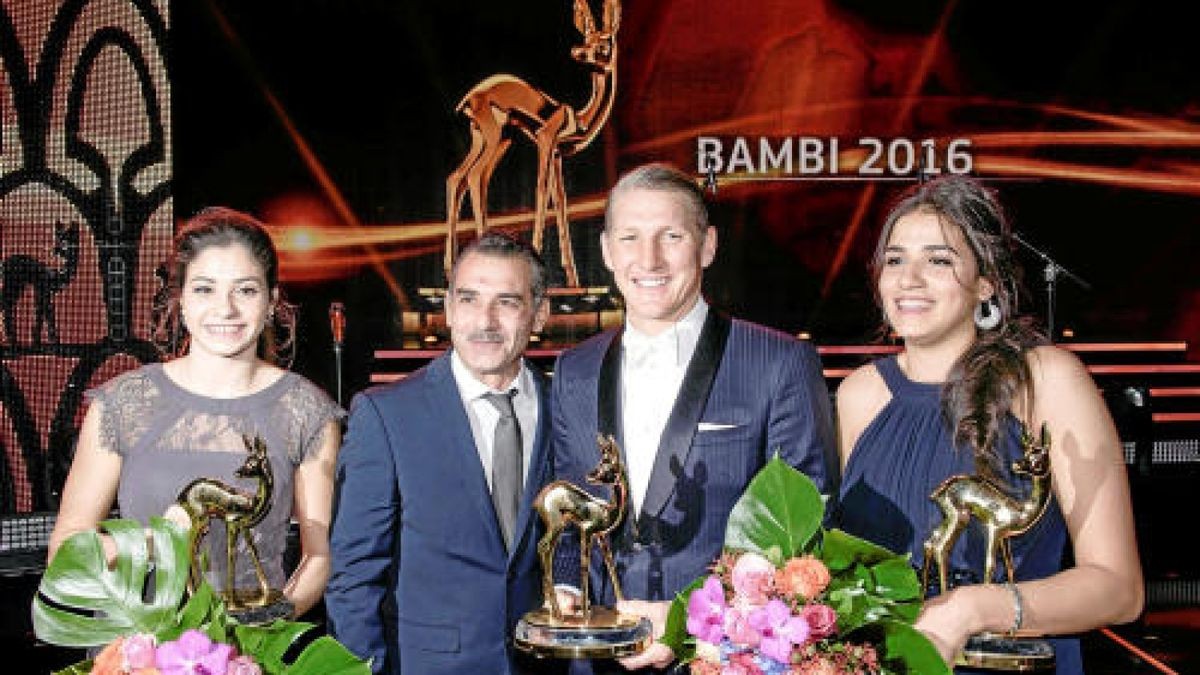 Yusra und Sarah Mardini, ihr Vater Mohamed Ezzat Mardini (2.v.l) und Bastian Schweinsteiger zeigen am 17.11.2016 in Berlin am Ende der Gala ihre Bambis. Die Preise wurden in diesem Jahr zum 68. Mal verliehen. Foto: Clemens Bilan/dpa +++(c) dpa - Bildfunk+++