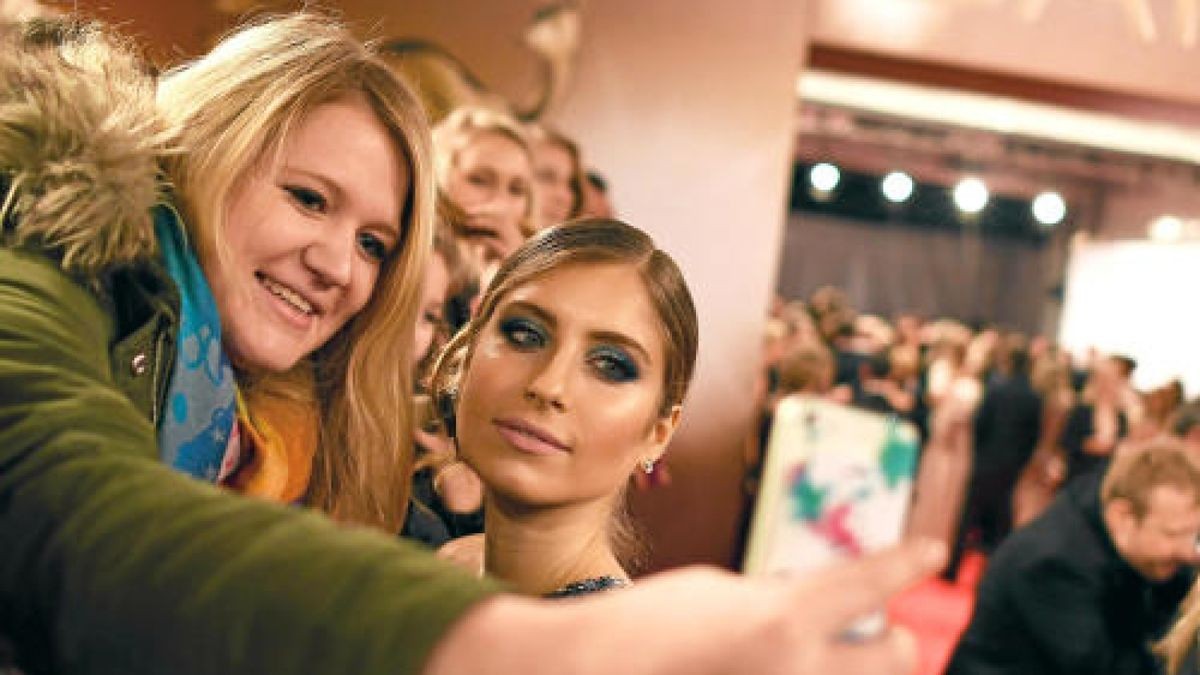 Cathy Hummels posiert am 17.11.2016 in Berlin zur 68. Verleihung des Medienpreises Bambi für ein Selfie mit einer Zuschauerin. Foto: Jens Kalaens/dpa +++(c) dpa - Bildfunk+++