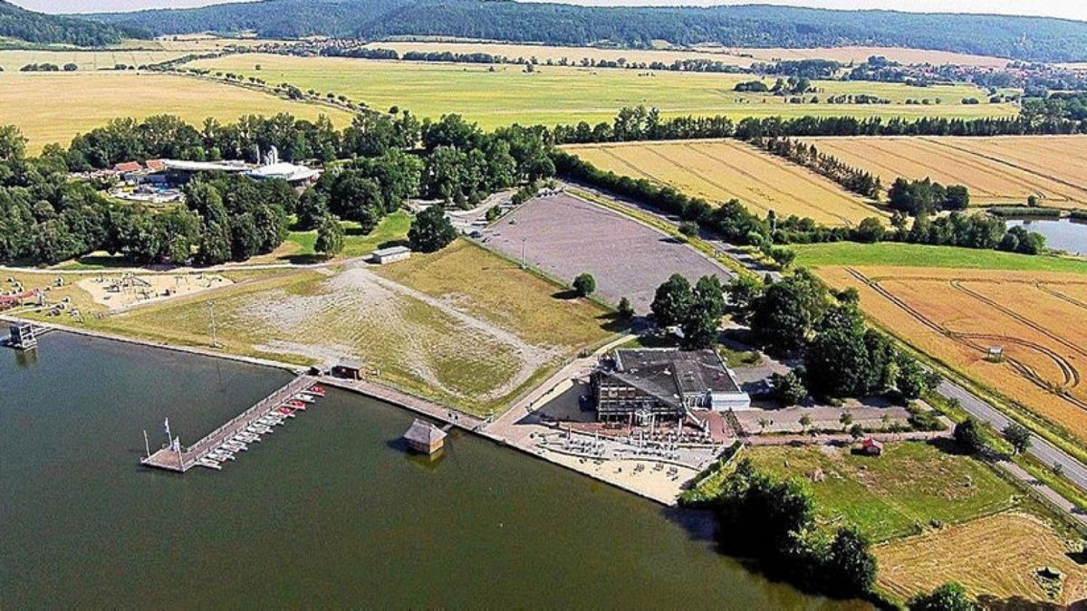 Das Drohnenfoto des Stausees Hohenfelden zeigt die Bootsanlegestelle und den Badestrand vorm Gaststättenkomplex. Im Hintergrund ist die Avenida-Therme zu erkennen.