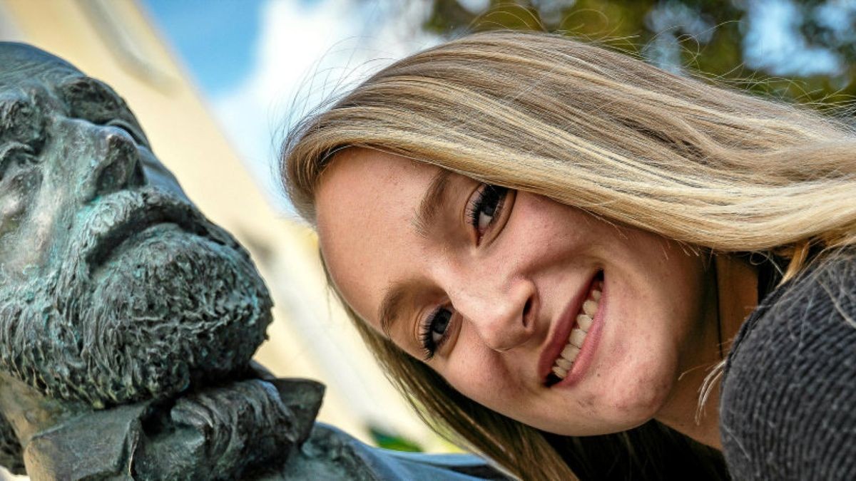 Chantal Mantek schmiegt sich an die kürzlich aufgestellte Bronzeskulptur von Carl Zeiß am neugestalteten Johannisplatz in Jena. Das Vermächtnis des Zeiss-Gründers wirkt bis heute.