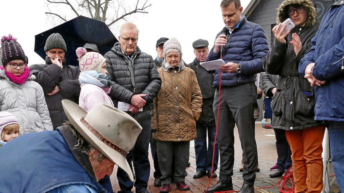 Während der Bildhauer Gunter Demnig die sieben Stolpersteine in den Bürgersteig am Oberen Steinweg in Niederorschel setzt, erzählt Bürgermeister Ingo Michalewski von dem Schicksal der Familie Unger.