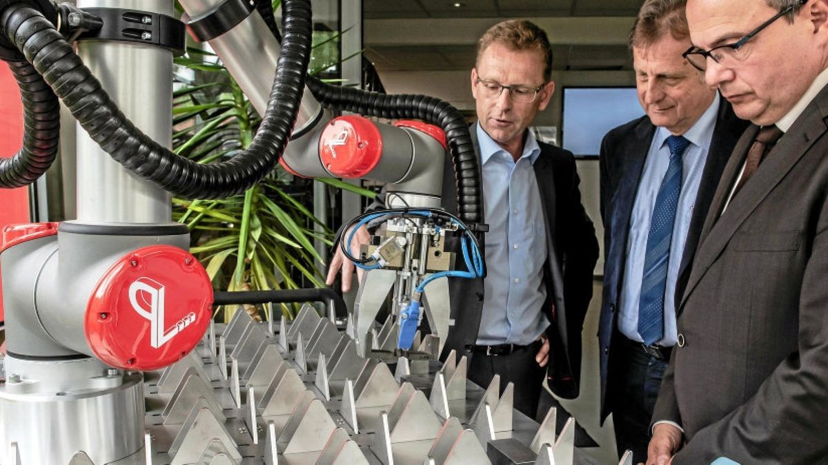 IWB-Geschäftsführer Ralf-Peter Kroschel erläutert Hartwig Harz, Leiter des Referates für Wirtschaftsförderung der Stadt Gotha und Oberbürgermeister Knut Kreuch (von links) einen Bestückungsroboter. Solche Anlagen gehören zum vielfältigen Produktportfolio der Firma.
