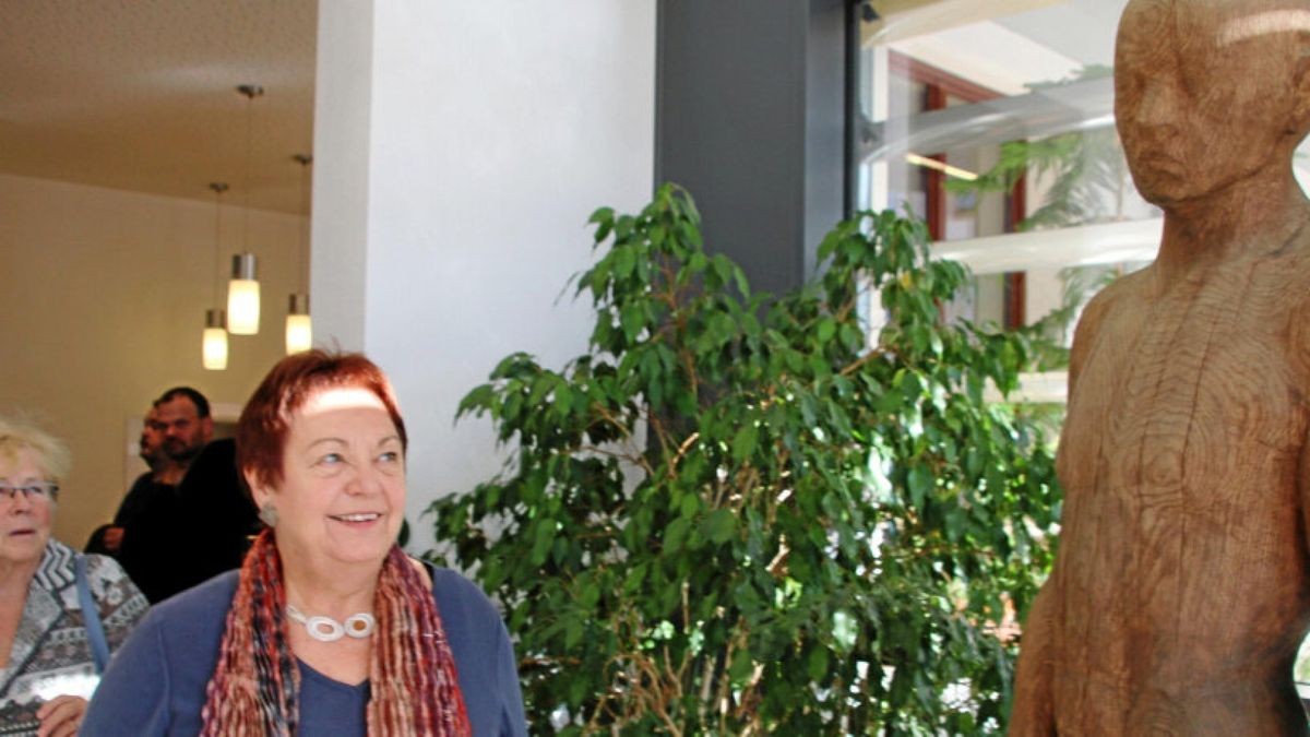 Helga Wilfroth neben der Holzskulptur „Neubeginn“ ihres Mannes Rüdiger Wilfroth, die jetzt mit der Stein-Skulptur „Großes Erwachen“ die Stadtbibliothek Gotha schmückt.