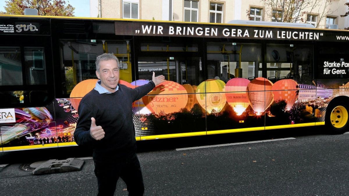 Michael Klau, Geschäftsführer der SD Verkehrsmedien Thüringen GmbH, präsentiert an einem Bus der GVB eine neue Leuchtfolie für Busse und Bahnen.