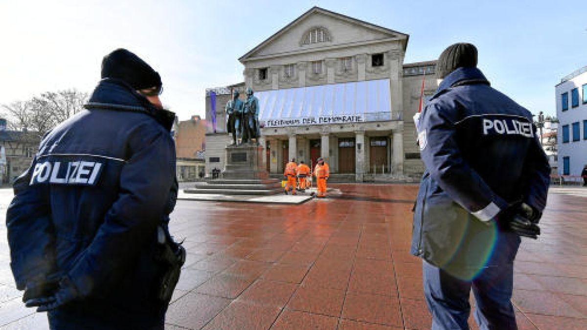 Polizisten stehen vor dem Goethe-Schiller-Denkmal und dem Deutschen Nationaltheater auf dem Theaterplatz.