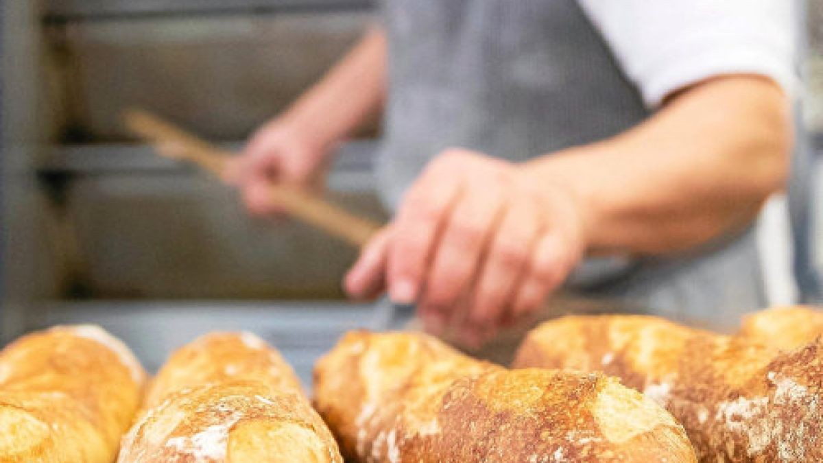 ARCHIV - 09.01.2019, Bayern, Dachsbach: Ein Bäcker- und Konditormeister legt in der Backstube eines Betriebs Baguettes aus dem Ofen auf ein Brett. Die Zahl der Bäckereien ist in den vergangenen Jahren stark zurückgegangen. Foto: Daniel Karmann/dpa +++ dpa-Bildfunk +++Foto: Daniel Karmann