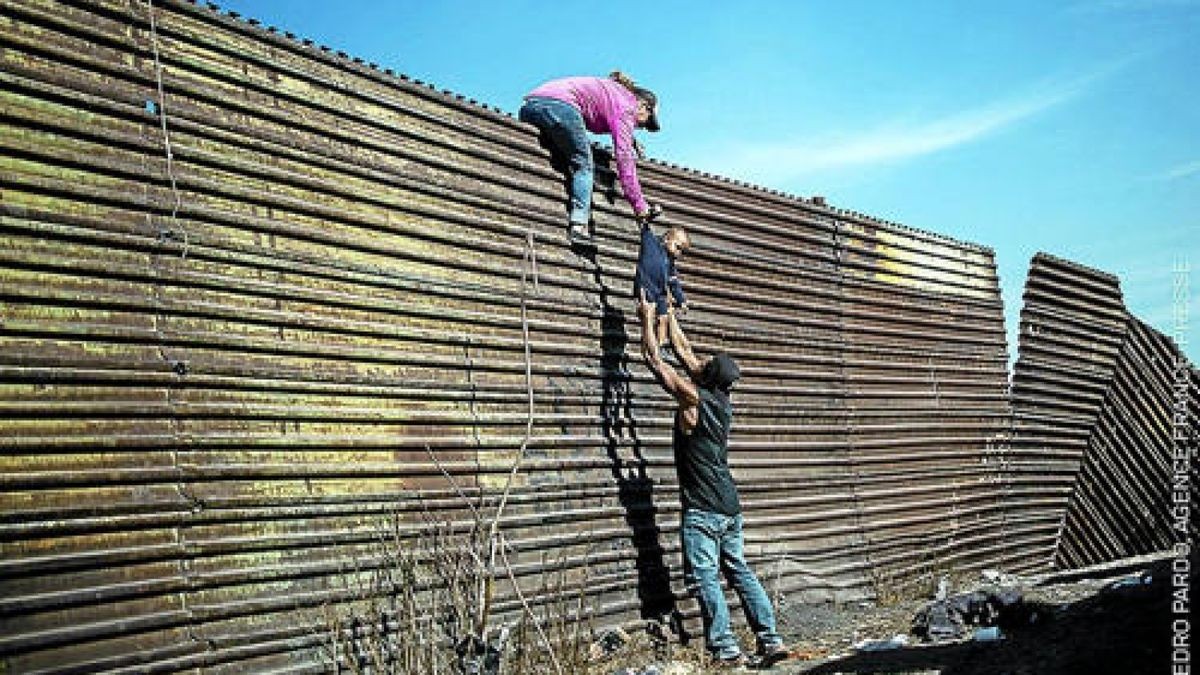 Migranten aus Mittelamerika klettern über die Grenze zwischen Mexiko und den USA unweit des Grenzüberganges El Chaparral. Sie gehören zur Flüchtlingskarawane, die sich von Honduras aus auf den Weg nach Norden machte. An der Grenze warteten bereits 3000 Menschen darauf, in die USA gelassen zu werden. Für seine Fotoserie erhielt Pedro Pardo den 3. Preis in der Kategorie Harte Fakten. Foto: Pedro Pardo/Agence France Presse