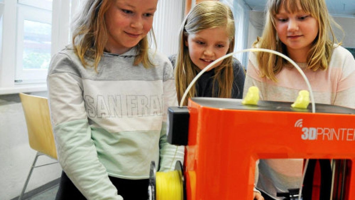 Die Viertklässlerinnen Marlene, Emilia und Josephine (v.l.) sehen dem 3D-Drucker bei der Arbeit zu.Foto: