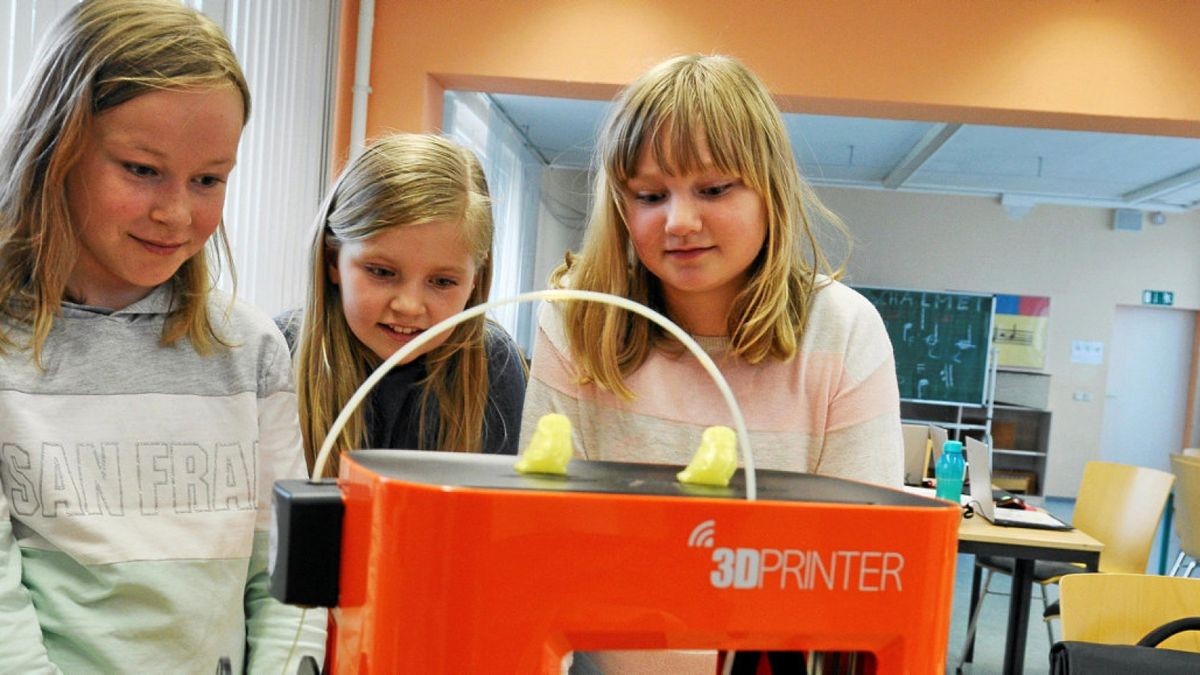 Die Viertklässlerinnen Marlene, Emilia und Josephine (v.l.) sehen dem 3D-Drucker bei der Arbeit zu. Foto: