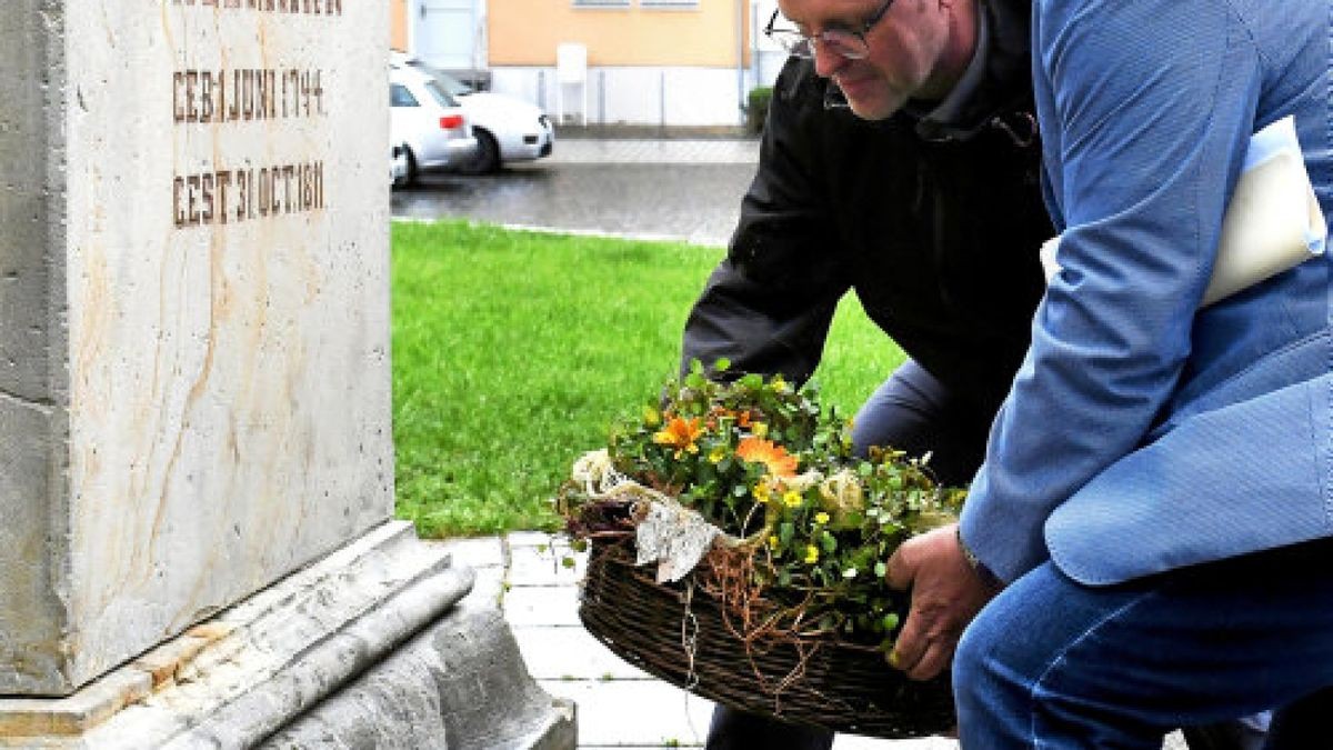 Bürgermeister Ralf Hauboldt (vorn) und Museumsleiter Ulf Molzahl legen eine Blumenschale am Salzmann-Obelisken vor der Bonifatiuskirche nieder. Dessen begonnene Sanierung soll in den nächsten Tagen von der beauftragten Steinmetzfirma abgeschlossen werden.Foto: Jens König