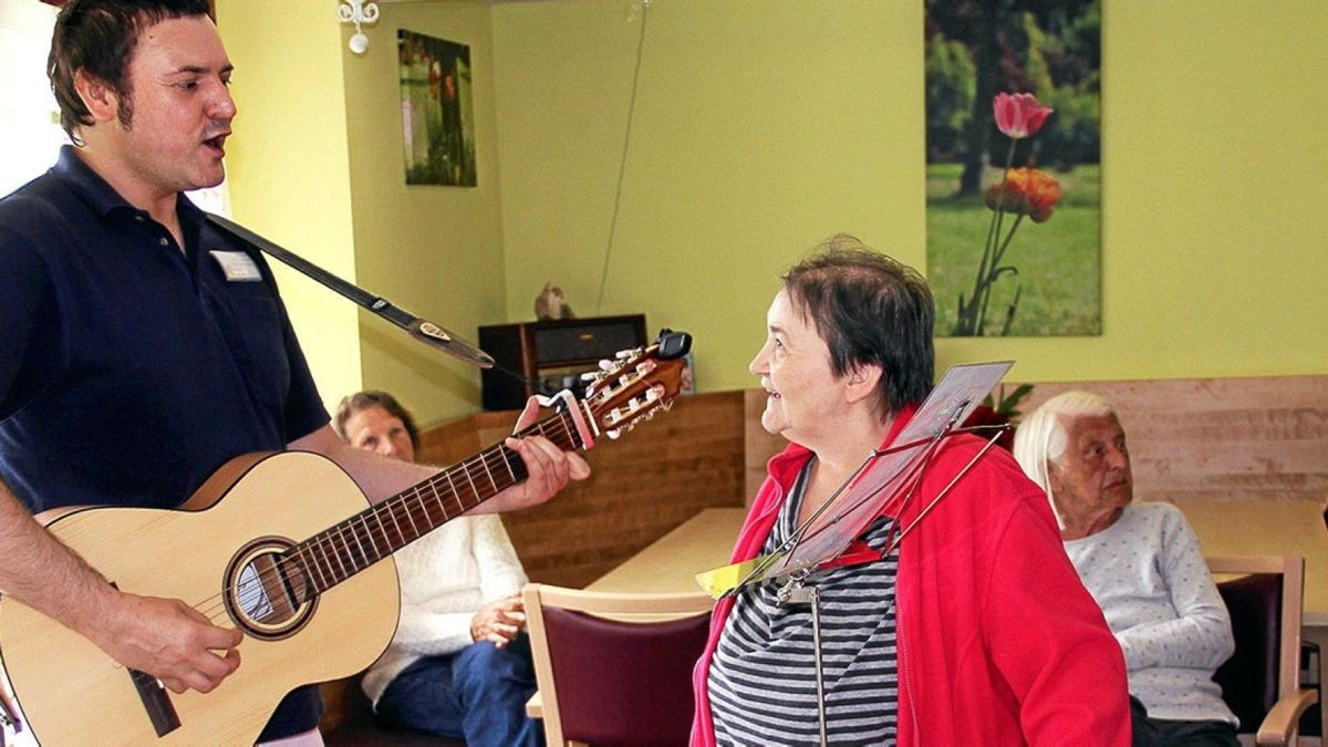 Der Musikgeragoge Denny Kais singt für die demenzkranken Bewohner des Sonnenhofes in Ilfeld. Monika Sievers hört ihm ganz begeistert zu.