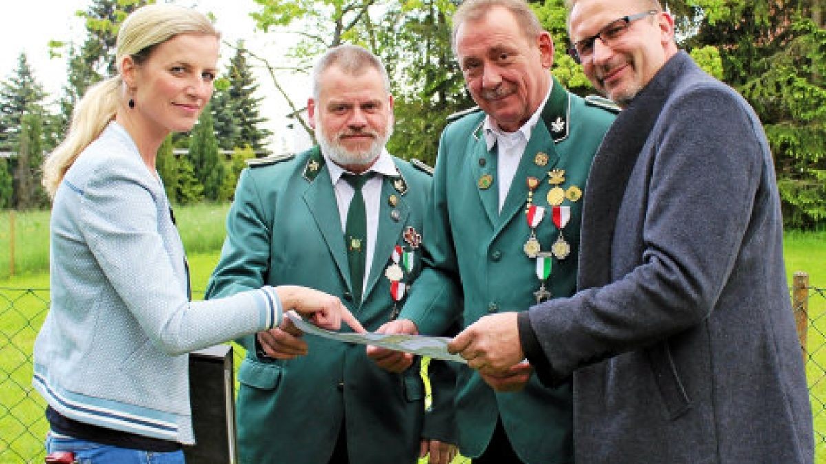 Architektin Anne Göbel zeigt dem Vorsitzenden des Schützenvereins Jens Hühn, dessen Stellvertreter Manfred Freund und Bürgermeister Klaus Zunke-Anhalt (von links) die Pläne. Auf dem Areal hinter ihnen soll der Spielplatz entstehen. Foto: Sabine Spitzer