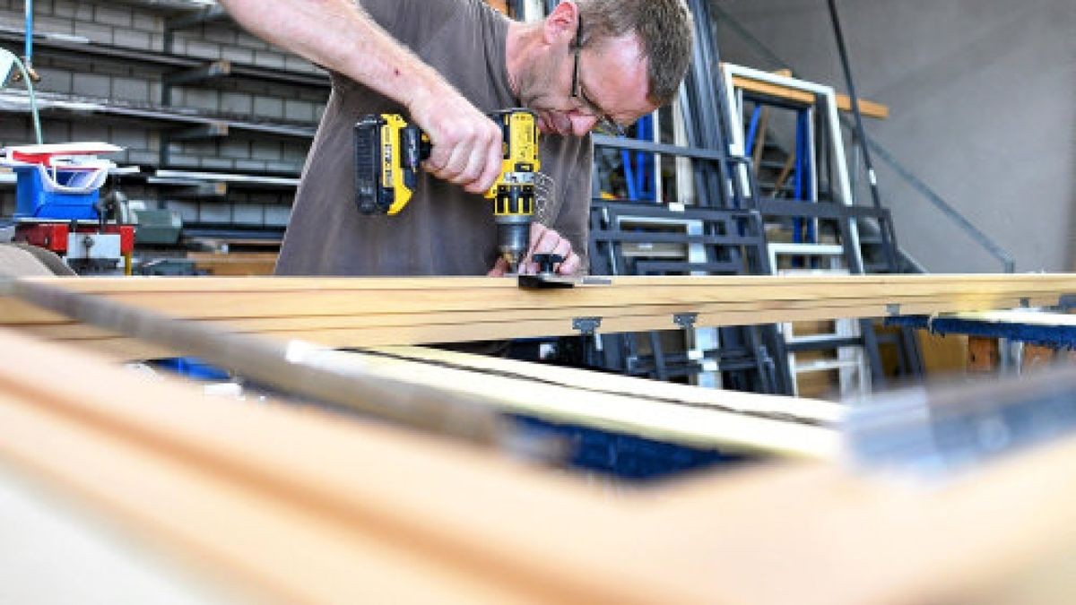 Werkstattleiter Silvio Lorber montiert bei FritzGlock in Hermsdorf an einer Fichte-Tür für einen französischen Balkon die Absturzsicherung: Dieser Schutz aus Glas ersetzt ein Metallgitter als Sturzschutz.Foto: Tino Zippel