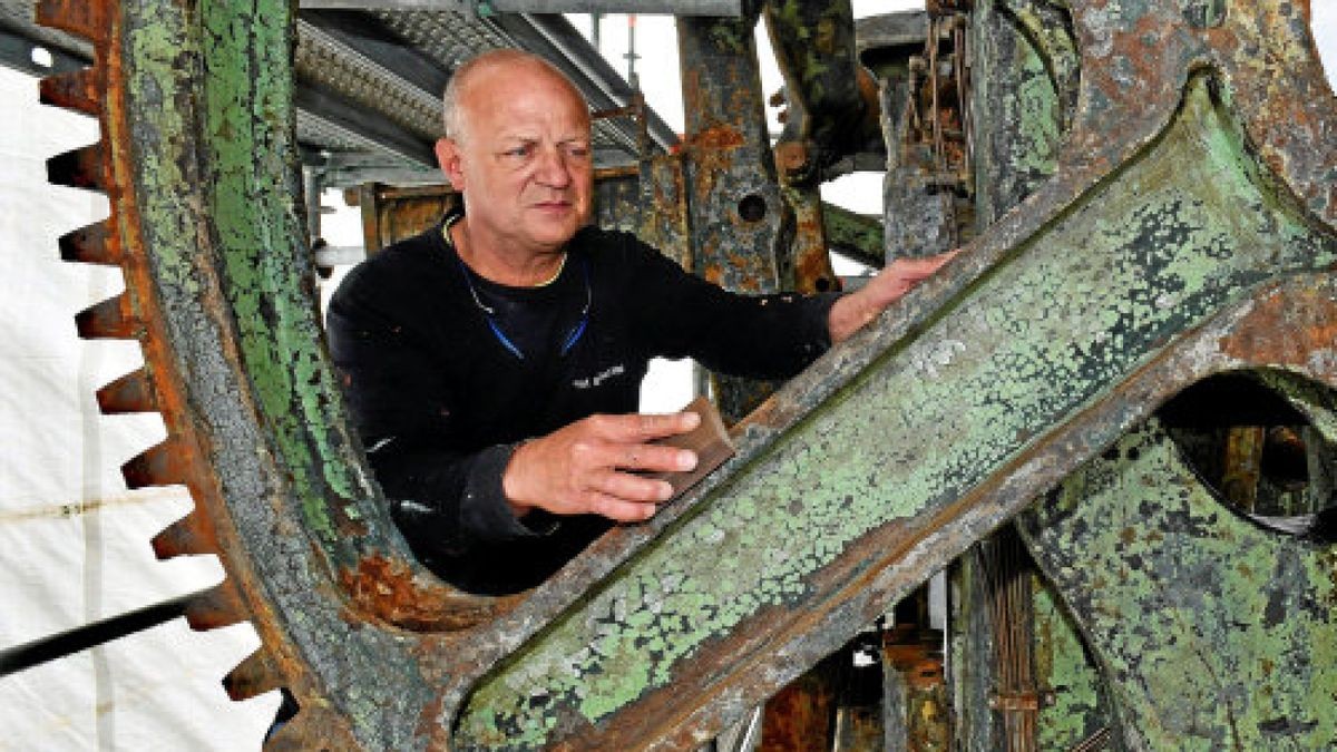 Der Metallrestaurator Bernhard Mai entfernt mit Schleifvlies an einem der beiden gewaltigen Zahnräder der Doppelkurbel-Kniehebel-Tiefziehpresse am Eingang vom Museum „automobile welt eisenach“ Schmutz und losen Rost sowie Farbe. Das Industriedenkmal wird Ende Juni fertig.Foto: Norman Meißner