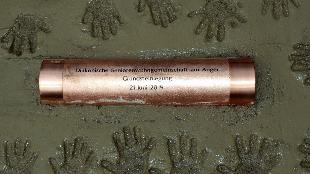 Mädchen und Jungen aus dem Ballstädter Kindergarten durften Grundsteinlegung für die Seniorenwohngemeinschaft ihre Handabdrücke in der Platte mit der Hülse, die Zeitdokumente enthält, hinterlassen. Die Platte wird später im Foyer eingebaut. Foto: Claudia Klinger