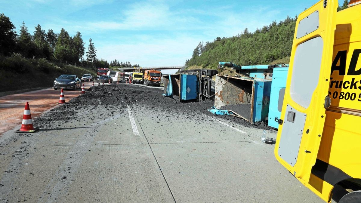 Das Fahrzeug liegt über alle drei Fahrstreifen. Die Ladung besteht nach ersten Erkenntnissen aus Klärschlamm, der sich ebenfalls auf der Fahrbahn verteilt hat.