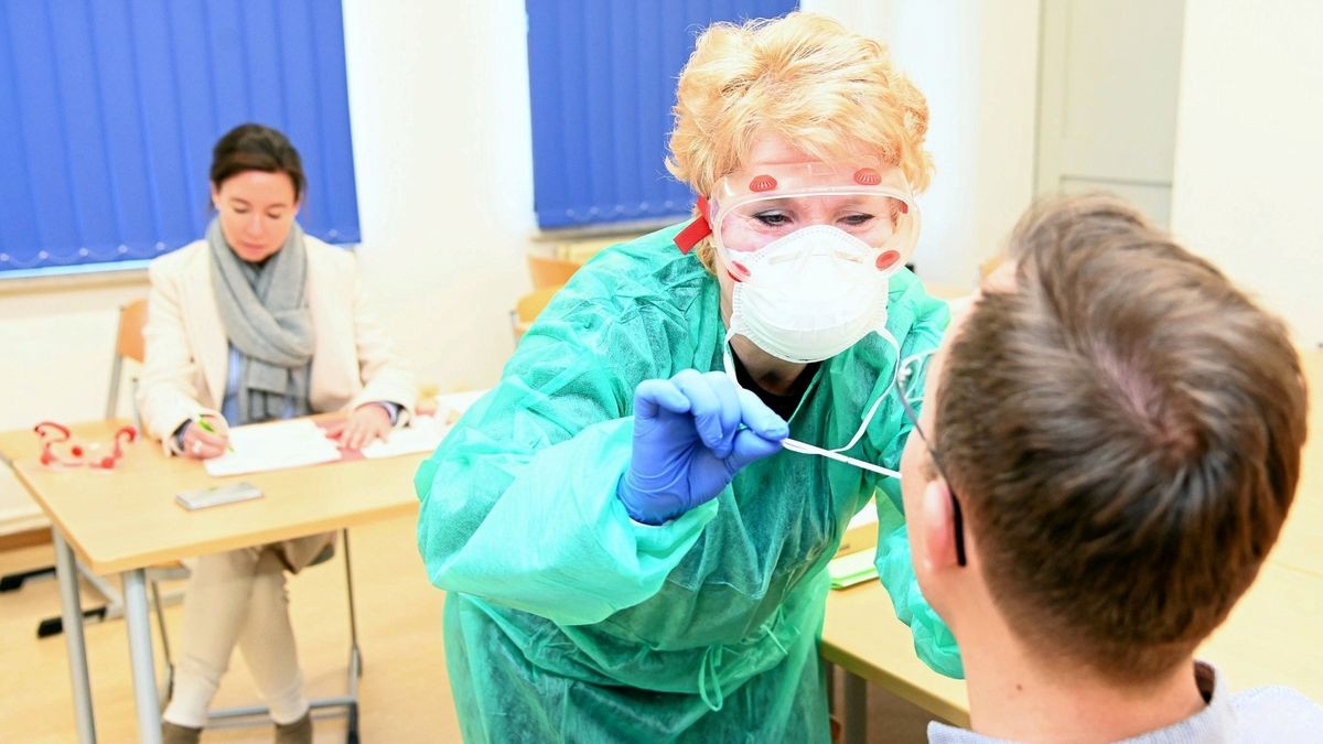 In der zusätzlichen Untersuchungseinrichtung des Gesundheitsamtes demonstriert Christiane Brandschwei einen Speichelabstrich.