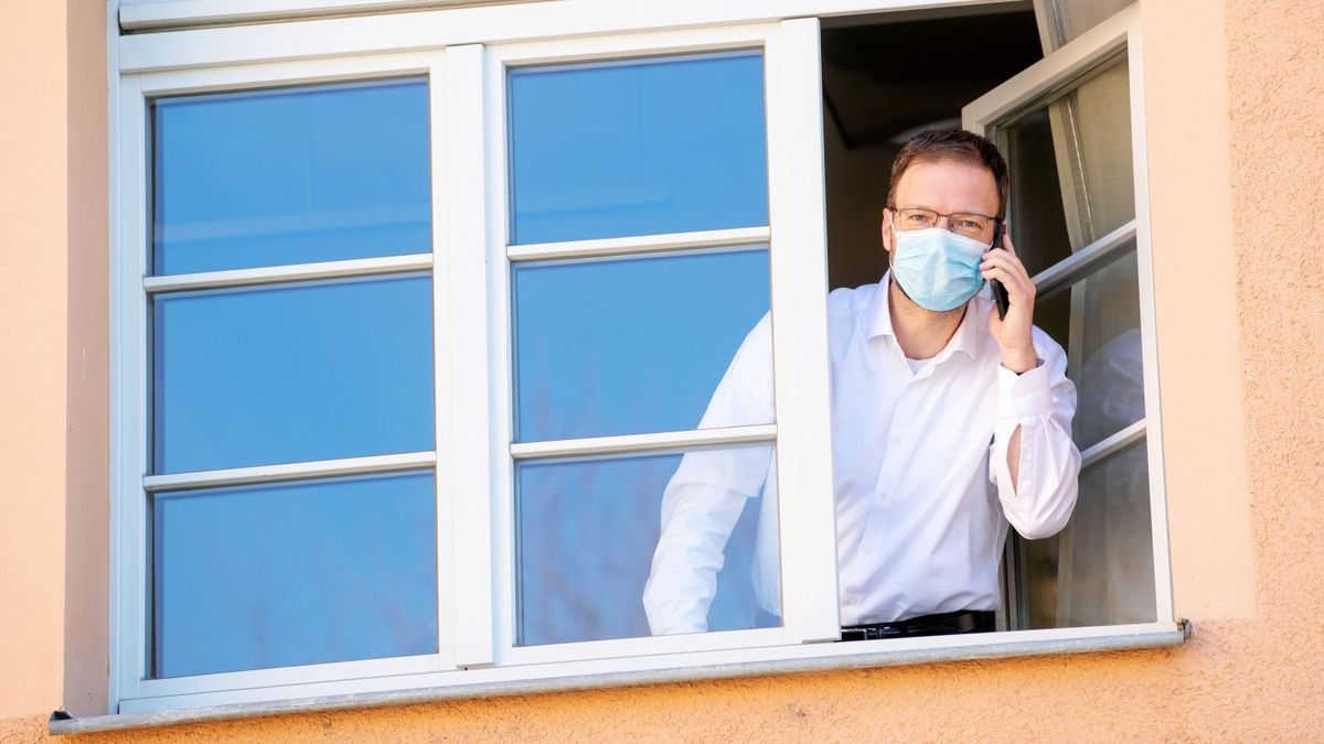 Der Jenaer Oberbürgermeister Thomas Nitzsche steht als Kontaktperson eines Corona-Erkrankten unter Quarantäne. Er telefoniert am Fenster seines Büros und trägt trotz negativem Testergebnis vorsorglich einen Mundschutz, um niemand zu infizieren.