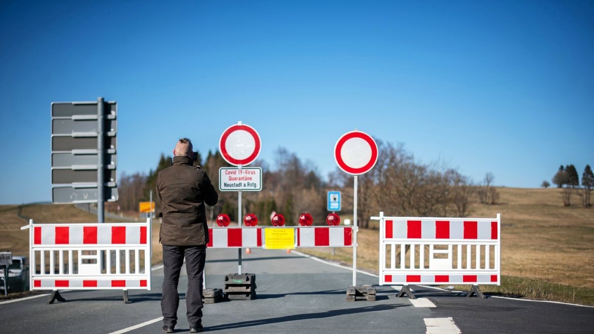 Ein TV-Journalist steht an einer Strassensperre an der gesperrten Straße nach Neustadt am Rennsteig.