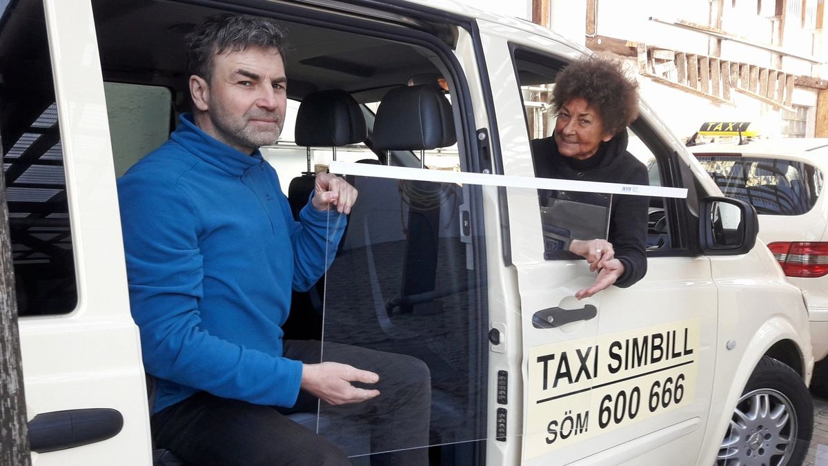 Taxiunternehmerin Monika Simbill und ihr Sohn Peter Leischner beim Einbau einer Corona-Hygieneschutzscheibe.