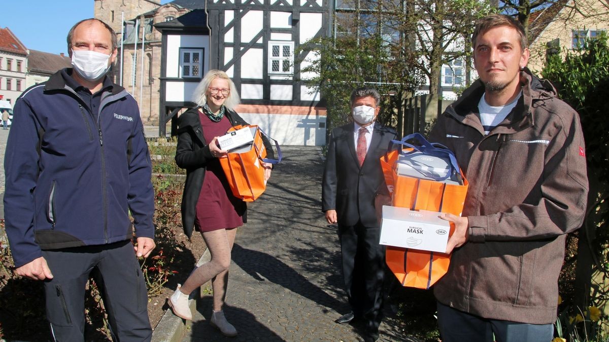 Nancy Liebig und Gunar Krüger (vorn rechts), Prokurist der Firma Schutec GmbH und Krüger-Maschinenbau, übergeben eine Spende von tausend Masken an Waltershausens Bürgermeister Michael Brychcy und Wehrleiter Torsten Fürtig (vorn links).