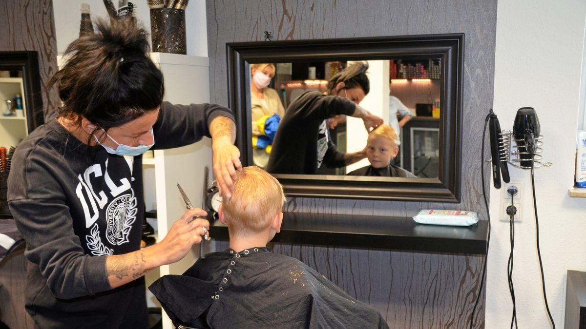 Carl bekommt von Sarah die Haare geschnitten. Handschuhe muss sie nur beim Waschen tragen.