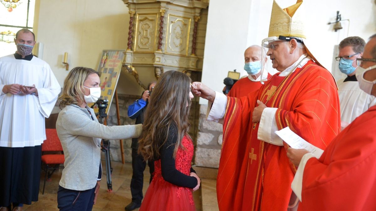 Firmung unter erschwerten Bedingungen: In Niederorschel im Eichsfeld empfingen Samstag 31 Menschen in zwei Gottesdiensten das Sakrament der Firmung von Weihbischof Reinhard Hauke, der aufgrund der Corona-Hygienemaßnahmen ein Schutzvisier trug. 