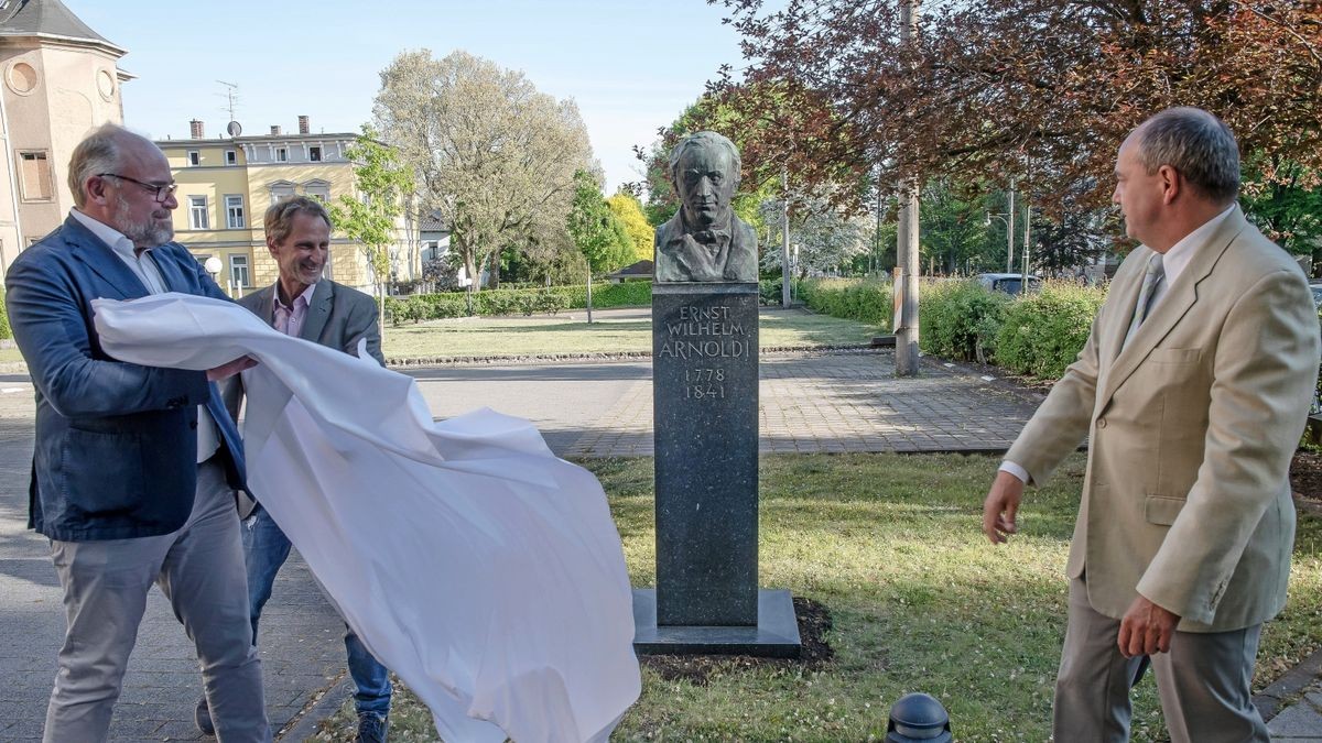 Christoph Ritter von Weber Chrustschoff, Gunnar Skerhut und Knut Kreuch (von links) enthüllen das nunmehr dritte Arnolid-Denkmal in Gotha vor dem Versicherungsmuseum.