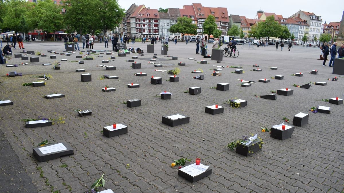 Der symbolische Friedhof auf dem Domplatz war eine Kunstinstallation mit Grabsteinen aus dunkel gestrichenen Pappkartons, mit Holzkreuzen, Kerzen und Blumenschmuck. Das Auf-die-Plätze-Bündnis lud Samstagnachmittag zur Mahnveranstaltung und wollte einen Kontrapunkt zu den „Spaziergängern“ setzen.