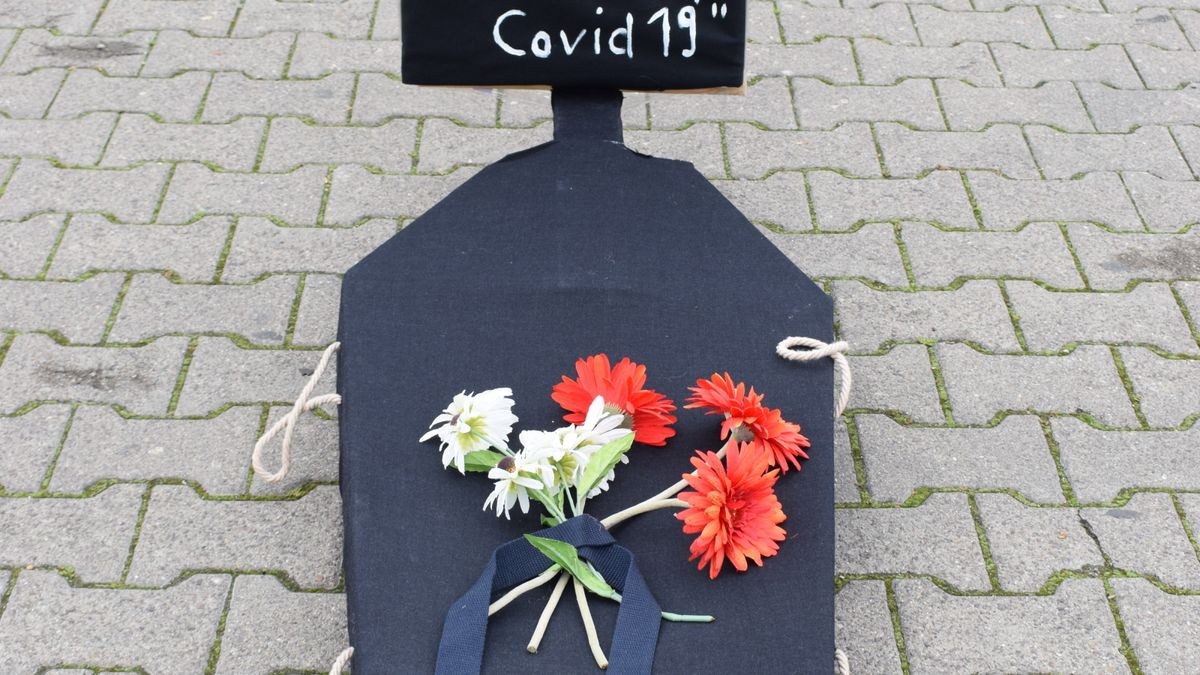 Der symbolische Friedhof auf dem Domplatz war eine Kunstinstallation mit Grabsteinen aus dunkel gestrichenen Pappkartons, mit Holzkreuzen, Kerzen und Blumenschmuck. Das Auf-die-Plätze-Bündnis lud Samstagnachmittag zur Mahnveranstaltung und wollte einen Kontrapunkt zu den „Spaziergängern“ setzen.