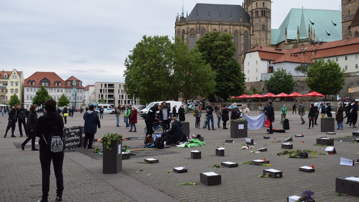 Der symbolische Friedhof auf dem Domplatz war eine Kunstinstallation mit Grabsteinen aus dunkel gestrichenen Pappkartons, mit Holzkreuzen, Kerzen und Blumenschmuck. Das Auf-die-Plätze-Bündnis lud Samstagnachmittag zur Mahnveranstaltung und wollte einen Kontrapunkt zu den „Spaziergängern“ setzen.