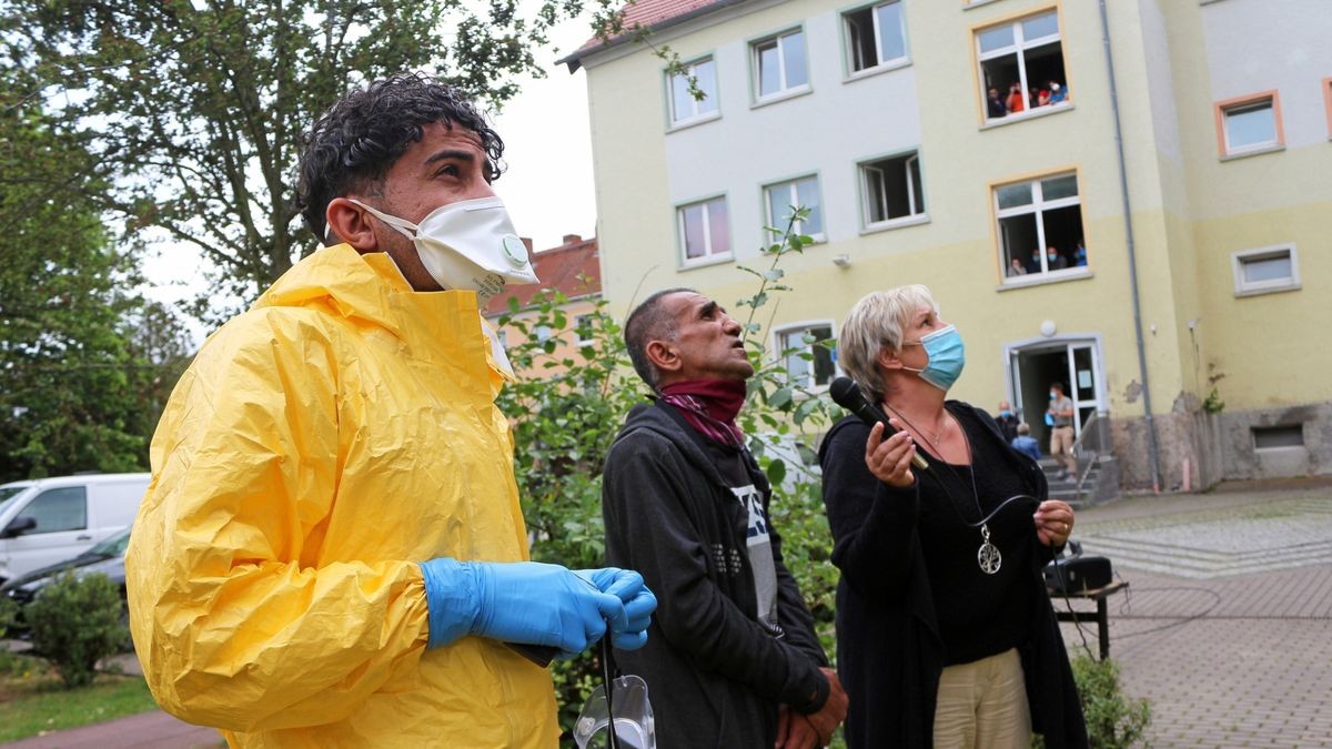 Die Bewohner werden an die Fenster gebeten, um sie über die Situation zu informieren. Romy Schröter (von rechts), Amtsleiterin für Ausländer und Flüchtlingswesen mit den Übersetzern Gulamgusein Mamedov und Qasim Hussain.