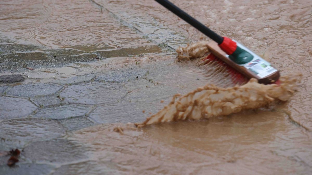 Die Feuerwehr versucht am Freitag, den überfluteten Rathenauplatz in Zeulenroda-Triebes von Unrat zu befreien. Nach einem heftigen Gewitter sind Wasser und Geröll von Feldern in die Stadt geflossen. Auch Anwohner helfen mit.