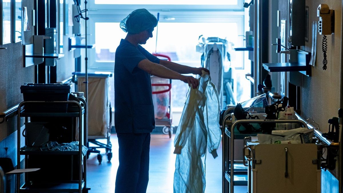 Eine Krankenschwester legt auf der Isolierstation für Coronavirus-Behandlungen einer Klinik Schutzkleidung an, bevor sie ein Patientenzimmer betritt (Archivbild). 