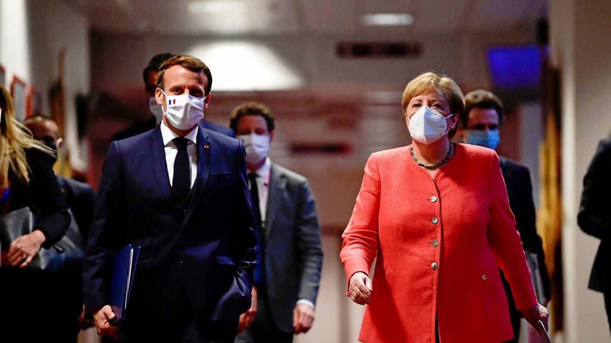 Frankreichs Präsident Emmanuel Macron und Kanzlerin Angela Merkel gehen nach Abschluss des EU-Gipfels in den Pressekonferenzraum. Die EU-Staaten haben sich im Kampf gegen die Corona-Wirtschaftskrise auf das größte Haushalts- und Finanzpaket ihrer Geschichte geeinigt.