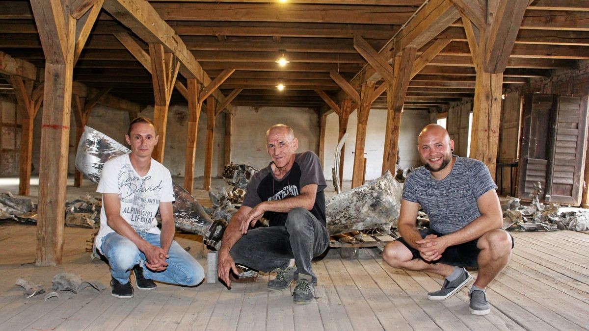 René Schütz, Bürgermeister Uwe-Karsten Saalfeld und Pierre Rudolf vor dem Flugzeugwrack, das 2019 im Ballhäuser Areal geborgen wurde.