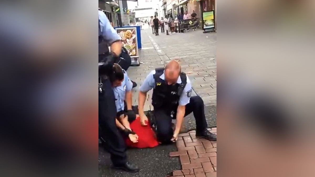 Ein Beamter der Düsseldorfer Polizei fixiert einen 15-jährigen Jugendlichen mit dem Knie auf dem Boden. Im Video scheint es nicht eindeutig ersichtlich, ob der Polizist erlaubterweise auf dem Kopf oder verbotenerweise auf dem Hals kniete. Die muslimische Gemeinde Masjid Assalam fordert nun eine rasche und transparente Aufklärung des Falls.