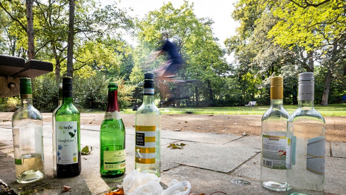 Leere Flaschen stehen neben einer Bank im Dreibrunnenpark.