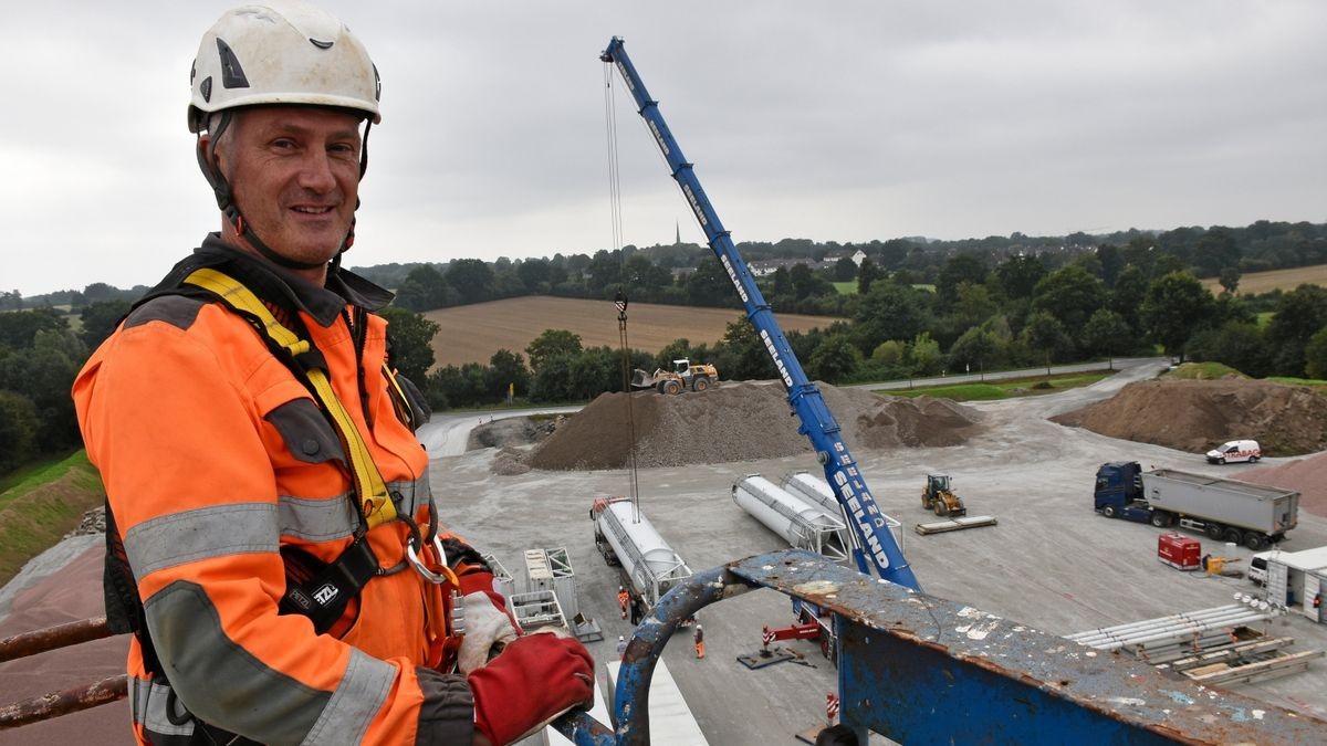 Uwe Peters montiert von der Plattform eines Hubsteigers aus in 27 Metern Höhe die Silos für die Betonmischanlage.