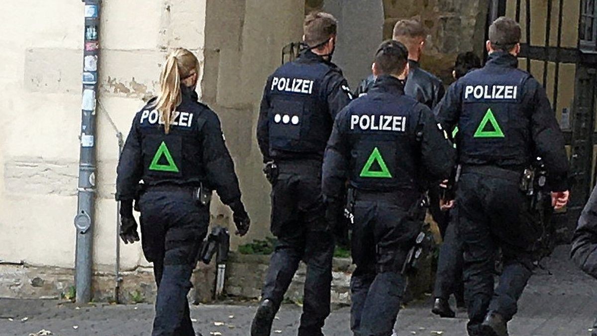 Die Polizeibeamten führen den Bräutigam in Richtung Domplatz ab.