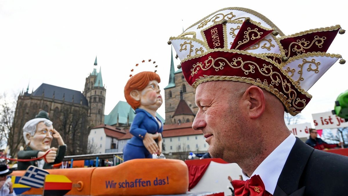 Thomas Kemmerich und ein Motivwagen mit Angela Merkel und Horst Seehofer im Hintergrund auf dem Domplatz. Das Bild ist ein Archiv-Bild.