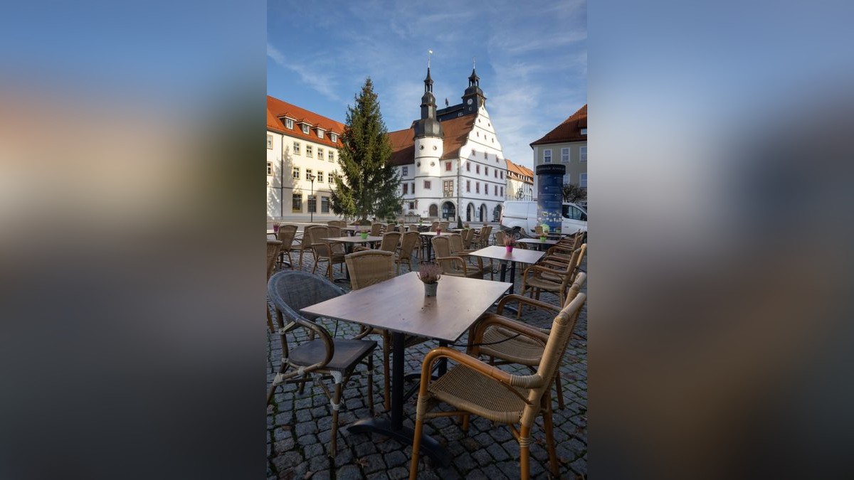 Leere Stühle stehen vor einem Cafe vor dem Rathaus. Das Infektionsgeschehen in der Corona-Pandemie hat im Landkreis Hildburghausen einen bundesweiten Höchststand erreicht.