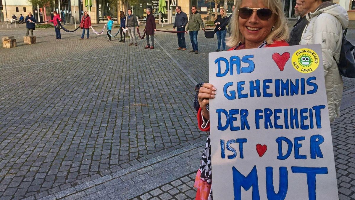 Die Eisenacherin Barbara Lindig mit einem Protestplakat beim Hygienespaziergang auf dem Eisenacher Marktplatz, für den Maskenpflicht besteht. Insgesamt beteiligen sich am Montagabend 150 Menschen, darunter zahlreiche Eltern aus Grundschulen.