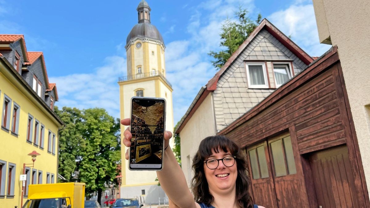 Christin Zander mit dem digitalen Kulturreiseführer mit dem Thema Bach in Ohrdruf und Wechmar, im Hintergrund der Turm der Michaeliskirche, an der Johann Christoph Bach Organist war.